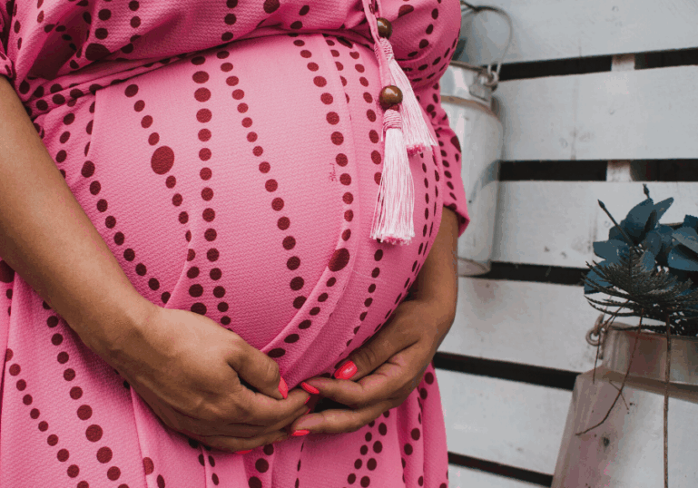 Untitled design (19) pregnant woman holding belly